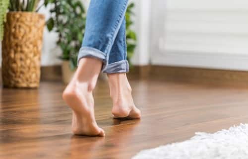 Immagine di piedi nudi su pavimento con riscaldamento a pavimento